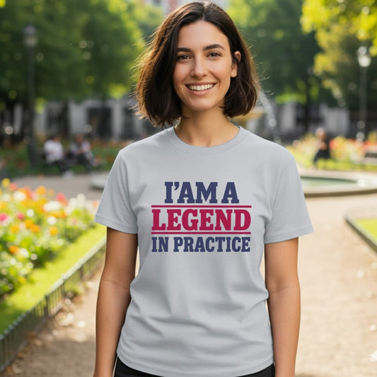 Light grey t-shirt with text "I'M A LEGEND IN PRACTICE" in blue and red.
