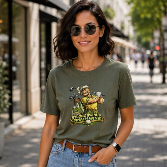 Olive green t-shirt with cartoon golfer and text "SPINACH STRONG SWINGS, SPINACH WINS!".