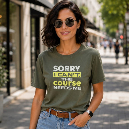 Woman wearing olive green t-shirt with text "SORRY I CAN'T. THE COURSE NEEDS ME."