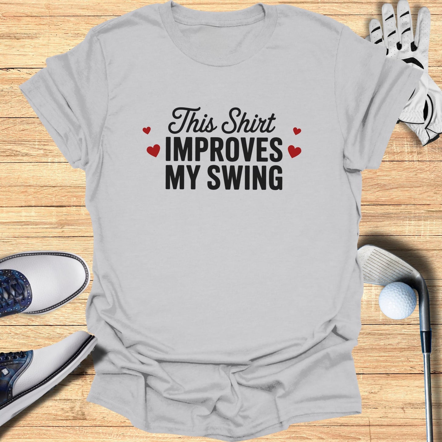 Grey t-shirt with "This Shirt Improves MY SWING" text and heart accents.