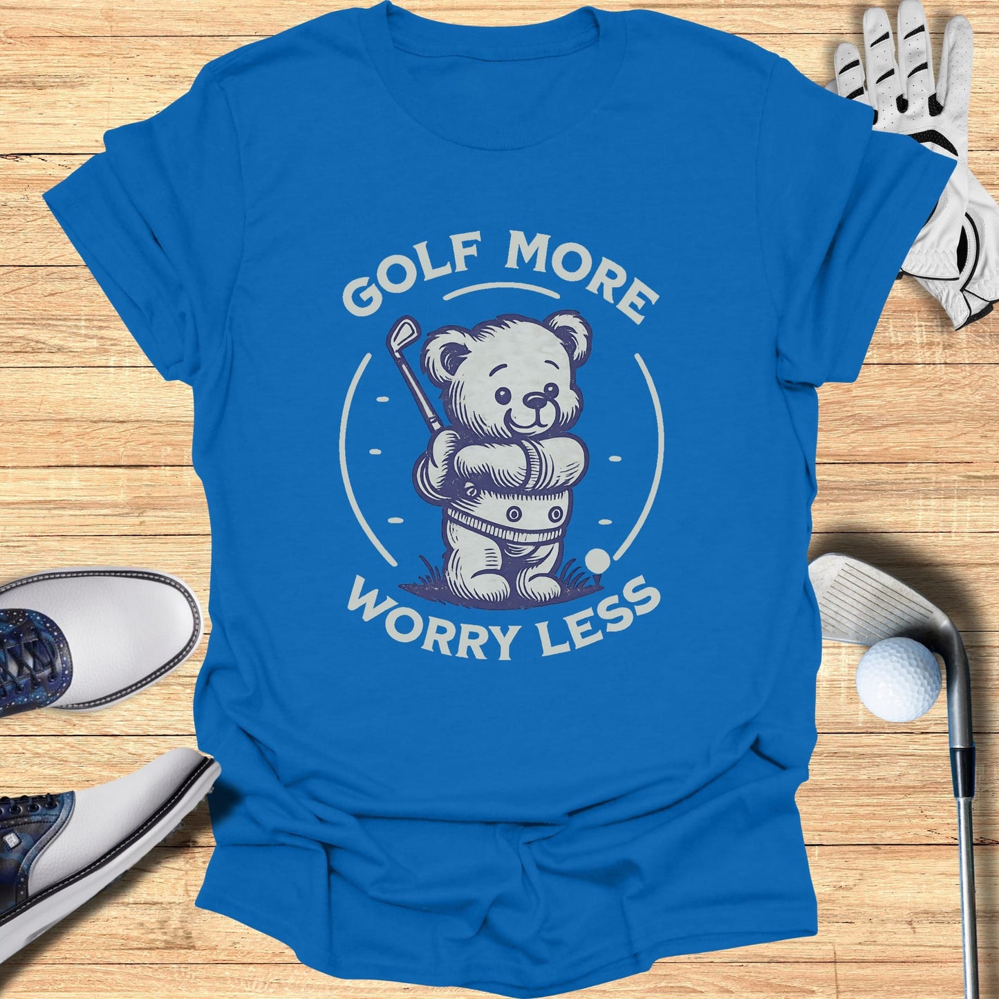 Blue t-shirt with cartoon bear playing golf, text "GOLF MORE WORRY LESS".