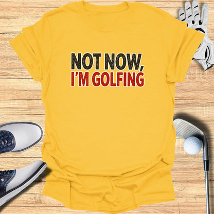 Yellow t-shirt with "NOT NOW, I'M GOLFING" text.