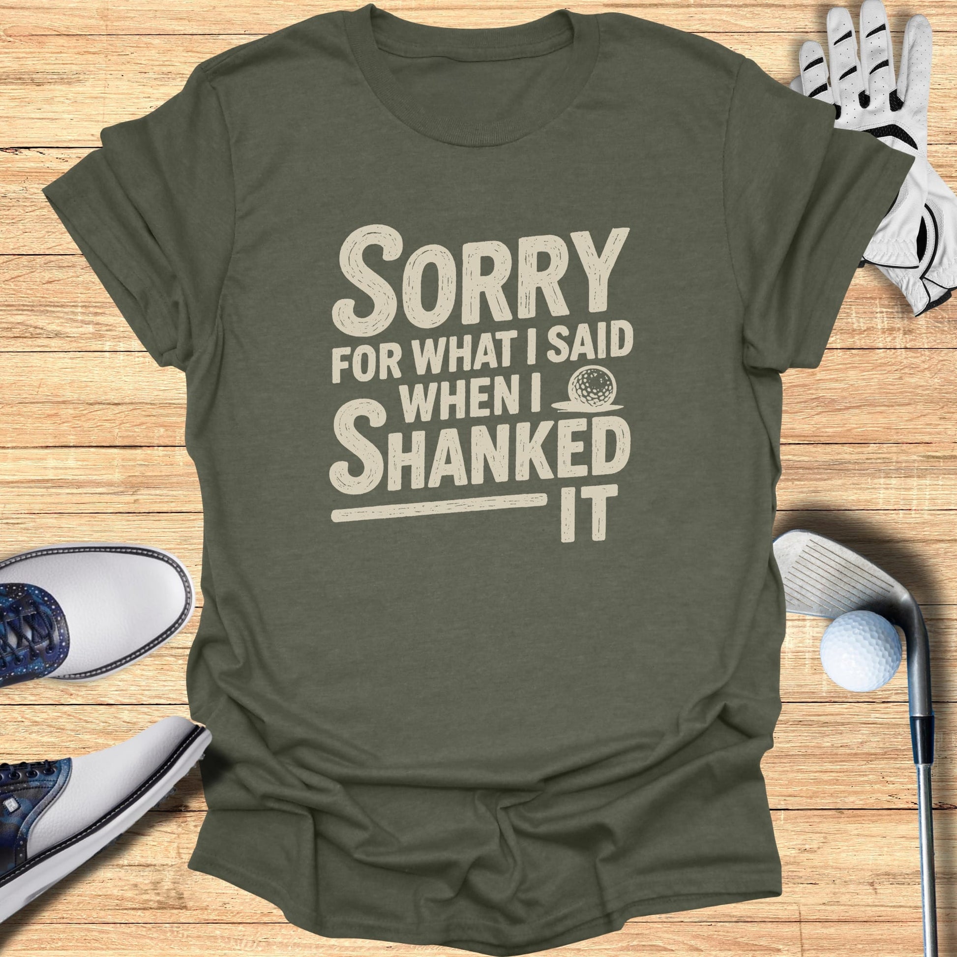 Olive t-shirt with "SORRY WHEN I SHANKED IT" text and golf accessories.