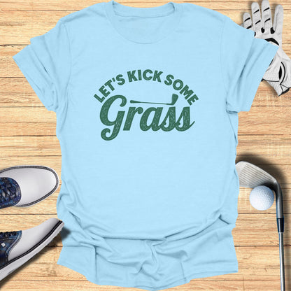 Light blue t-shirt with "Let's Kick Some Grass" text in green lettering.