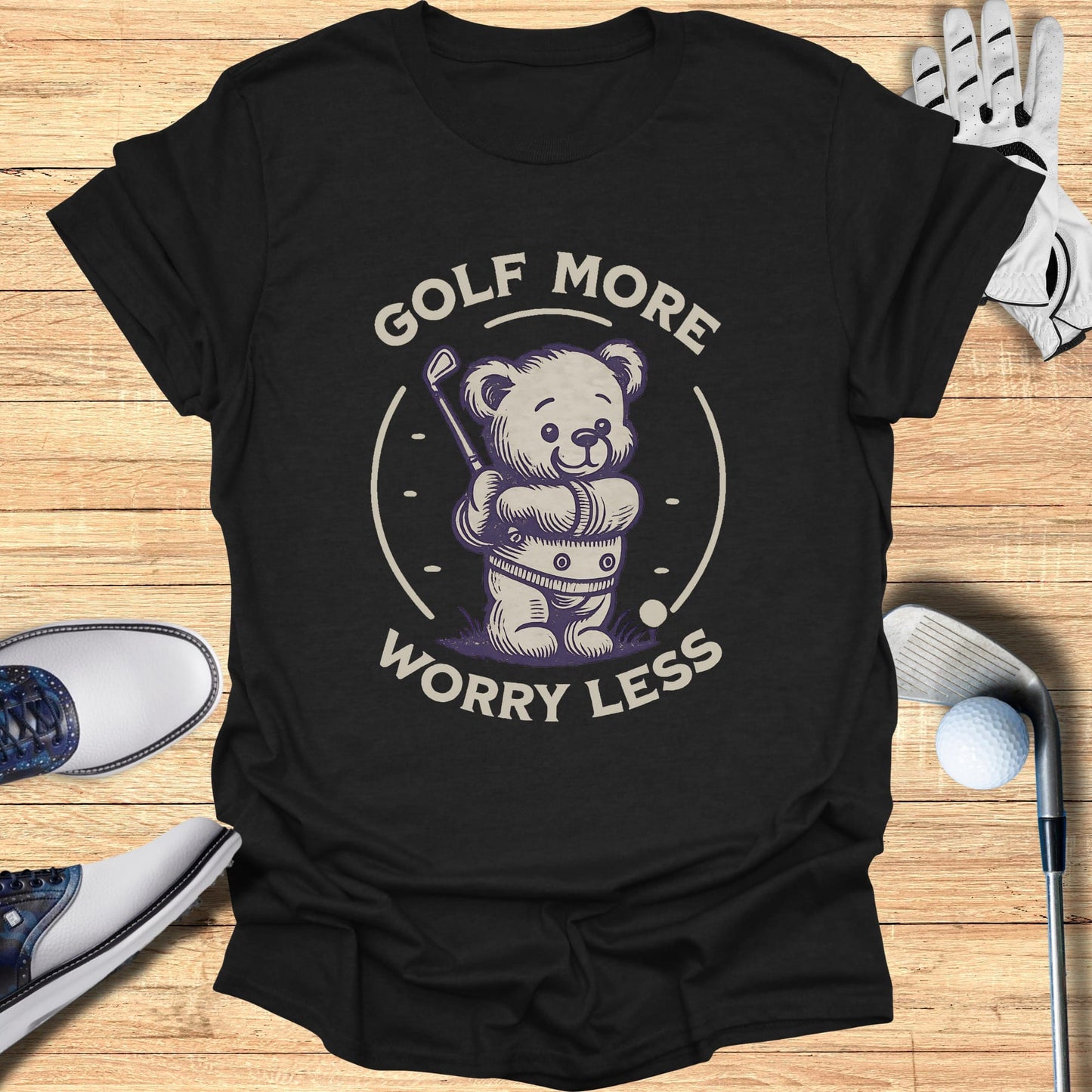 Bear wearing golf clothes holding a club on a dark t-shirt.