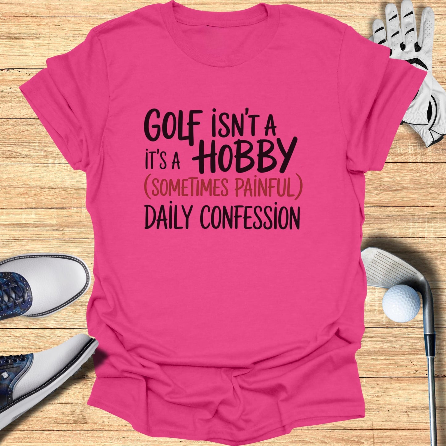 Pink t-shirt with "GOLF ISN'T A HOBBY (SOMETIMES PAINFUL) DAILY CONFESSION" text.