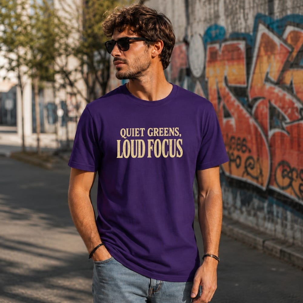 Man wearing a purple t-shirt with "QUIET GREENS, LOUD FOCUS" text.