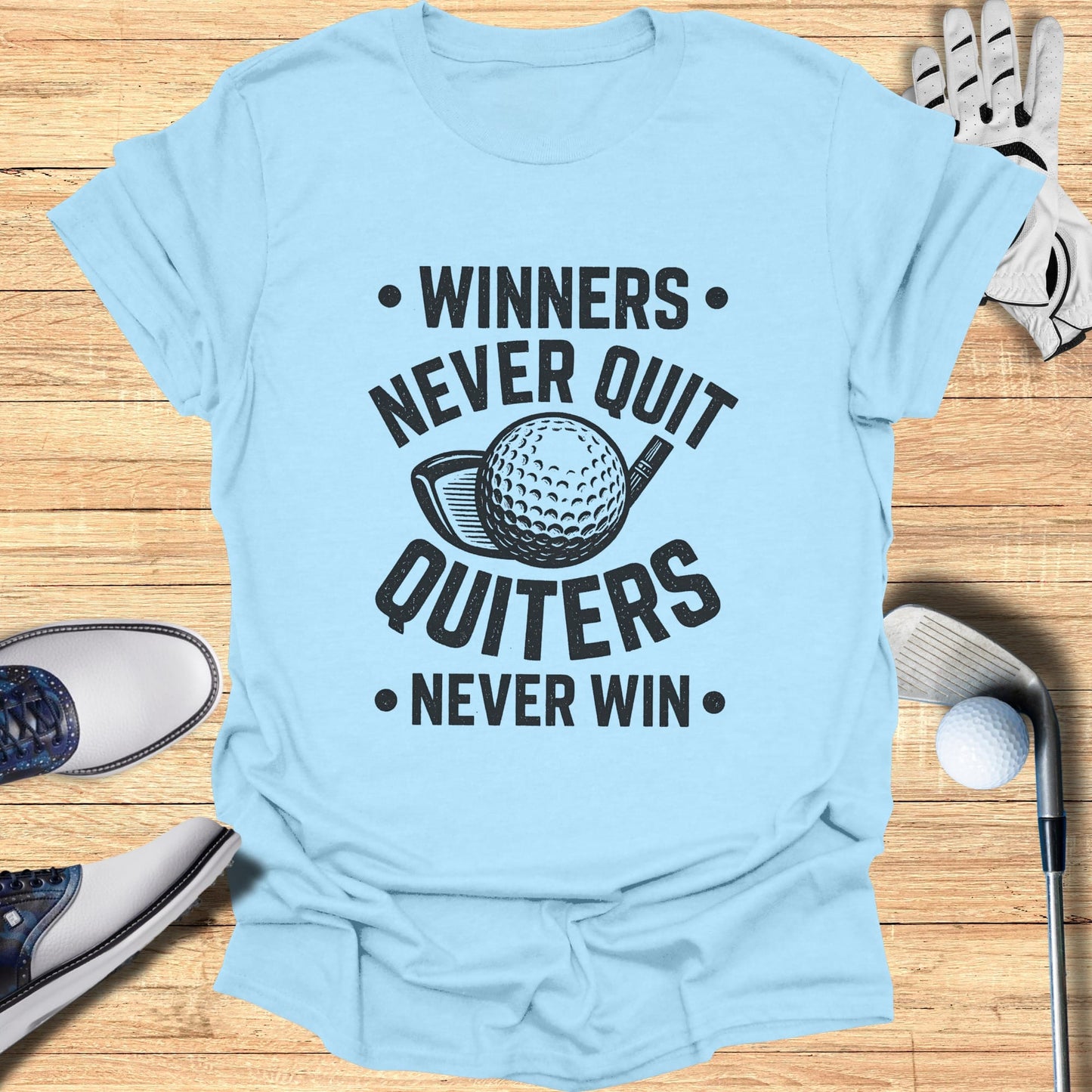 Light blue t-shirt with "Winners Never Quit, Quitters Never Win" and golf ball graphic.
