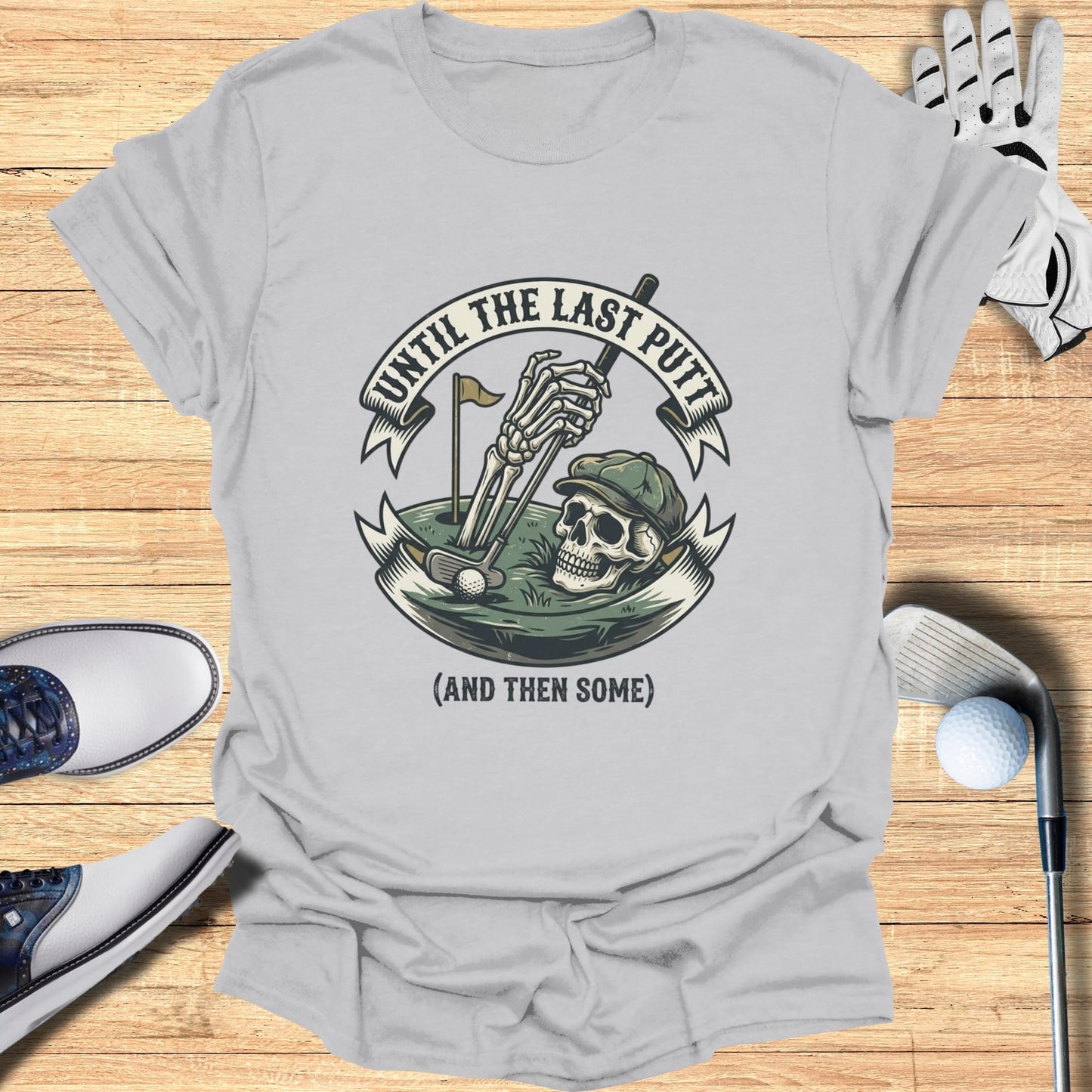 Gray t-shirt with skull golfing graphic and text "UNTIL THE LAST PUTT (AND THEN SOME)".