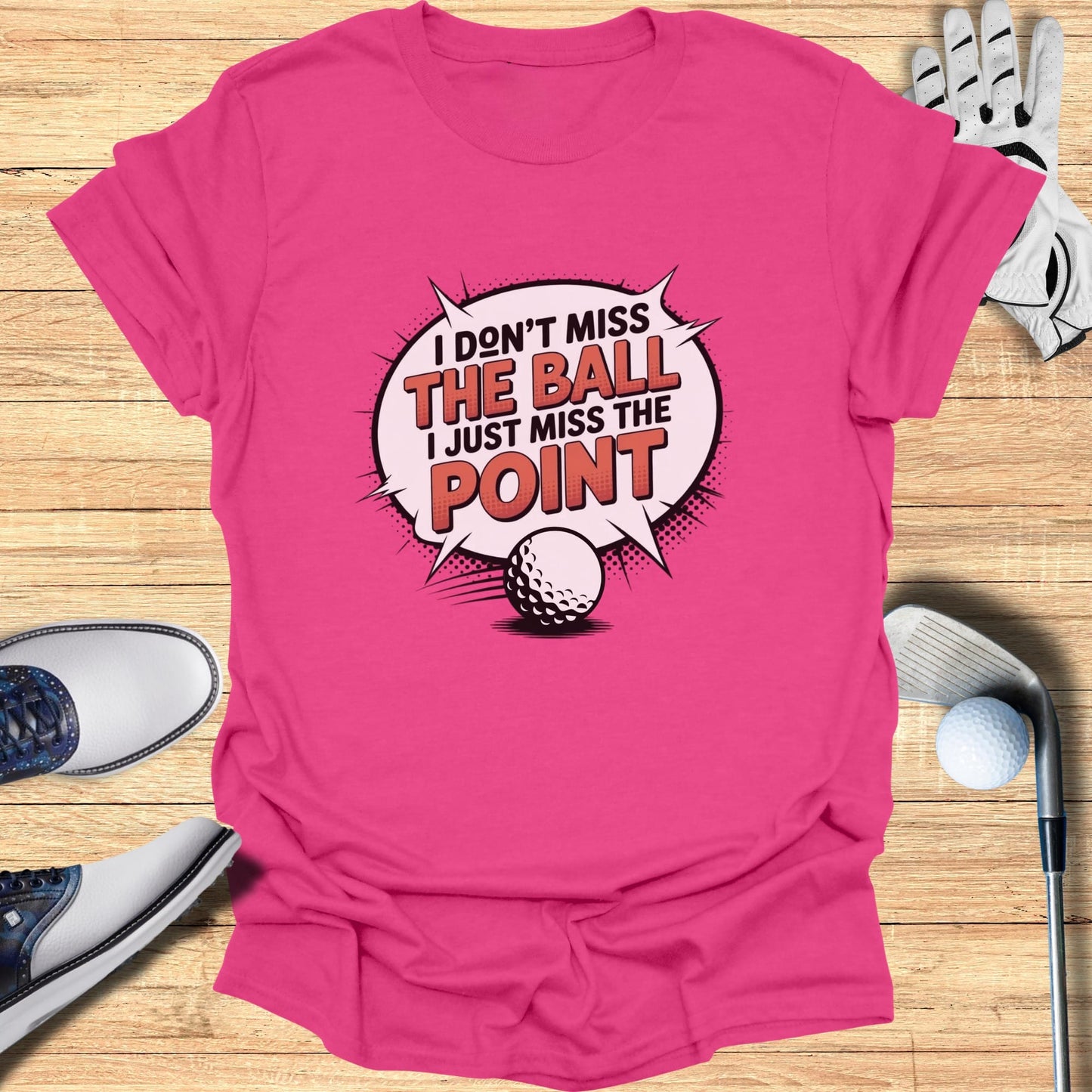 Pink t-shirt with "I don't miss the ball I just miss the point" text and golf ball graphic.