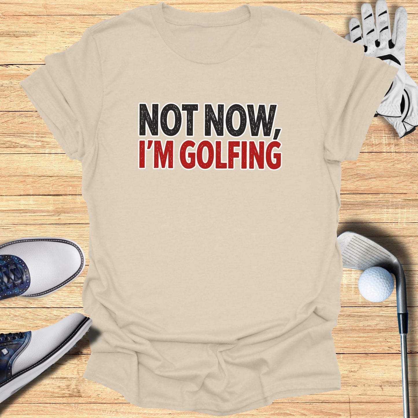 T-shirt with "NOT NOW, I'M GOLFING" text, golf club, glove, and shoes.