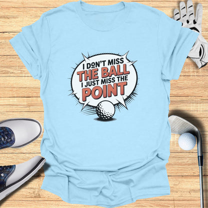 Light blue t-shirt with "I don't miss the ball, I just miss the point" text.