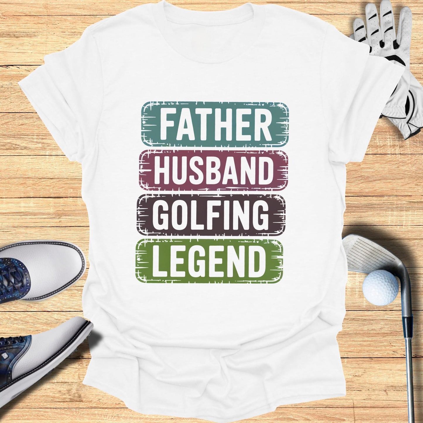 White t-shirt with "Father Husband Golfing Legend" text in colorful stripes.