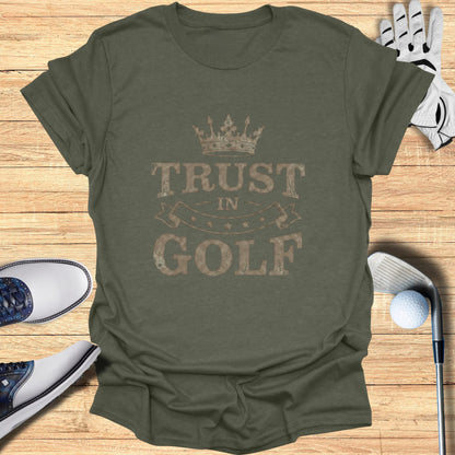 T-shirt with "Trust In Golf" text and crown graphic, with golf shoes and glove.