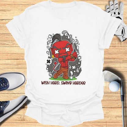 T-shirt with cartoon devil playing golf, text "Wish Hard. Swing Harder."