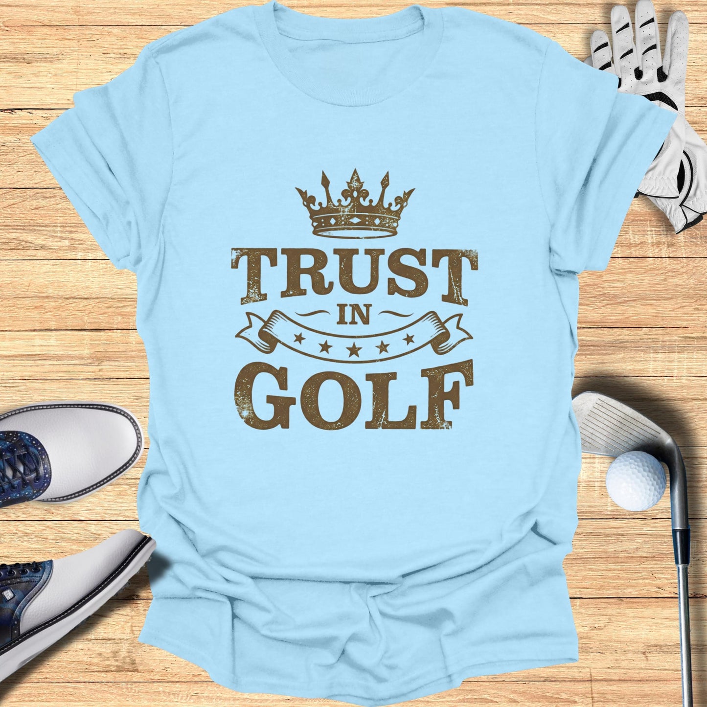 Light blue t-shirt with "TRUST IN GOLF" text and crown graphic.