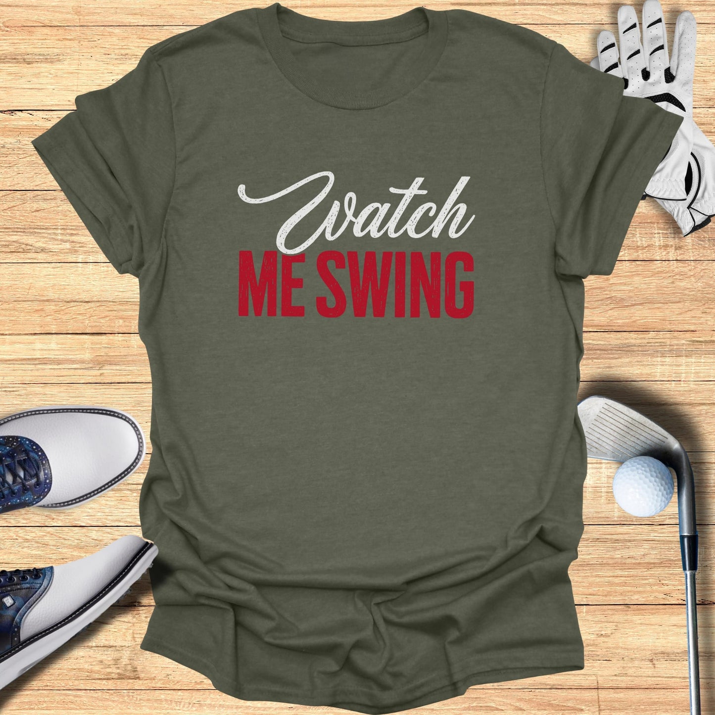 Olive green t-shirt with "Watch ME SWING" text, golf shoes, glove, and club.