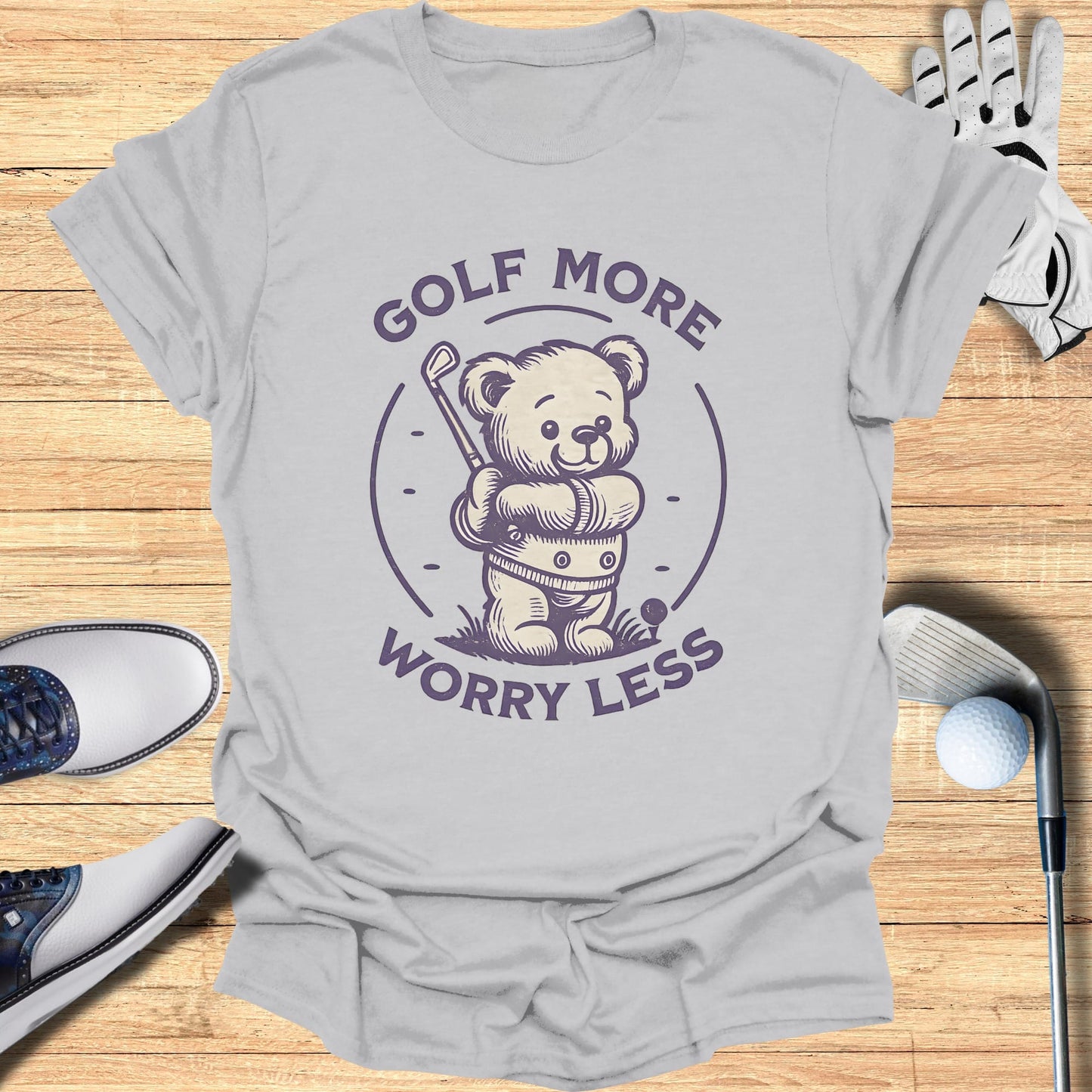 T-shirt with a teddy bear in a golf outfit holding a club.