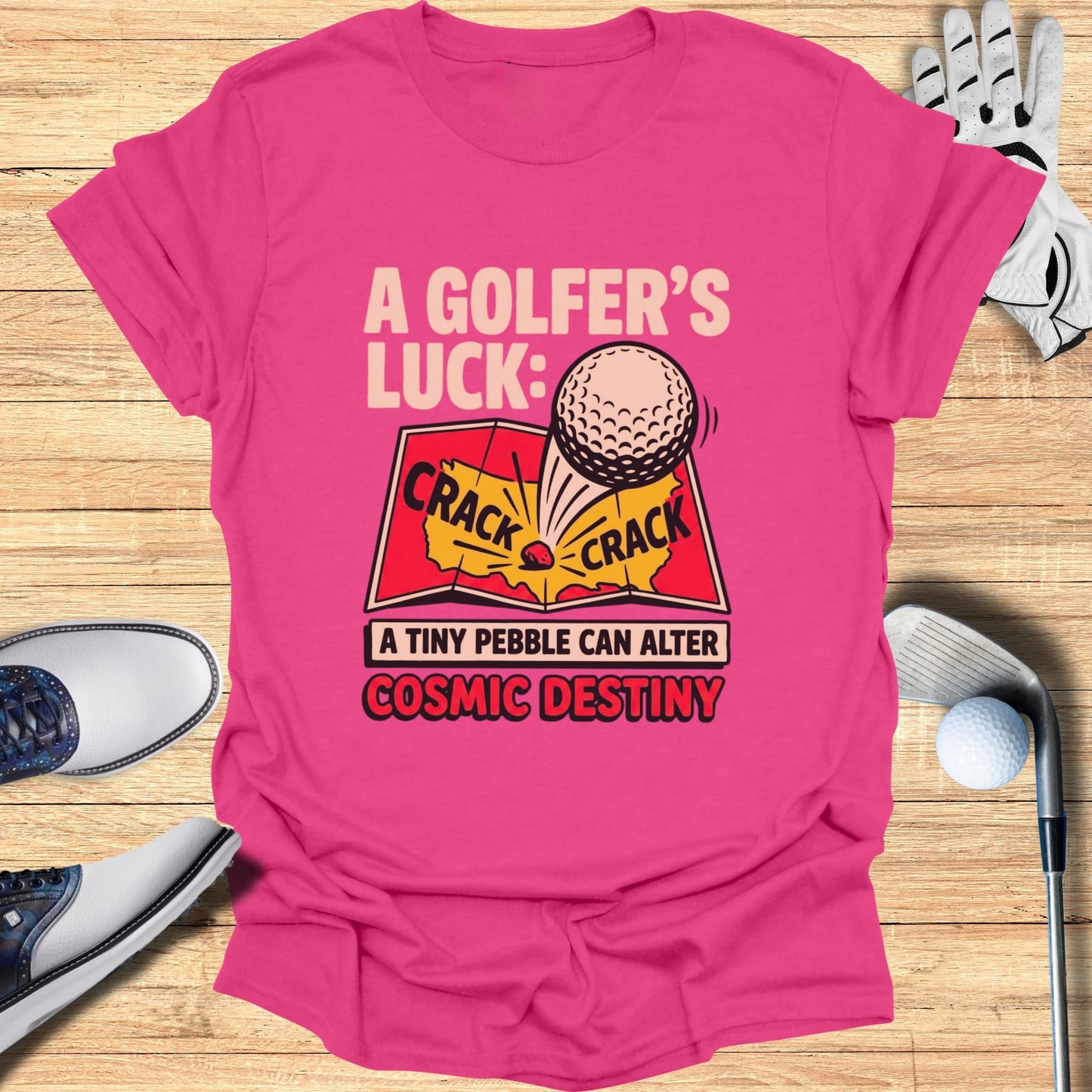 Pink t-shirt with "A Golfer's Luck: A Tiny Pebble Can Alter Cosmic Destiny" text and graphic.