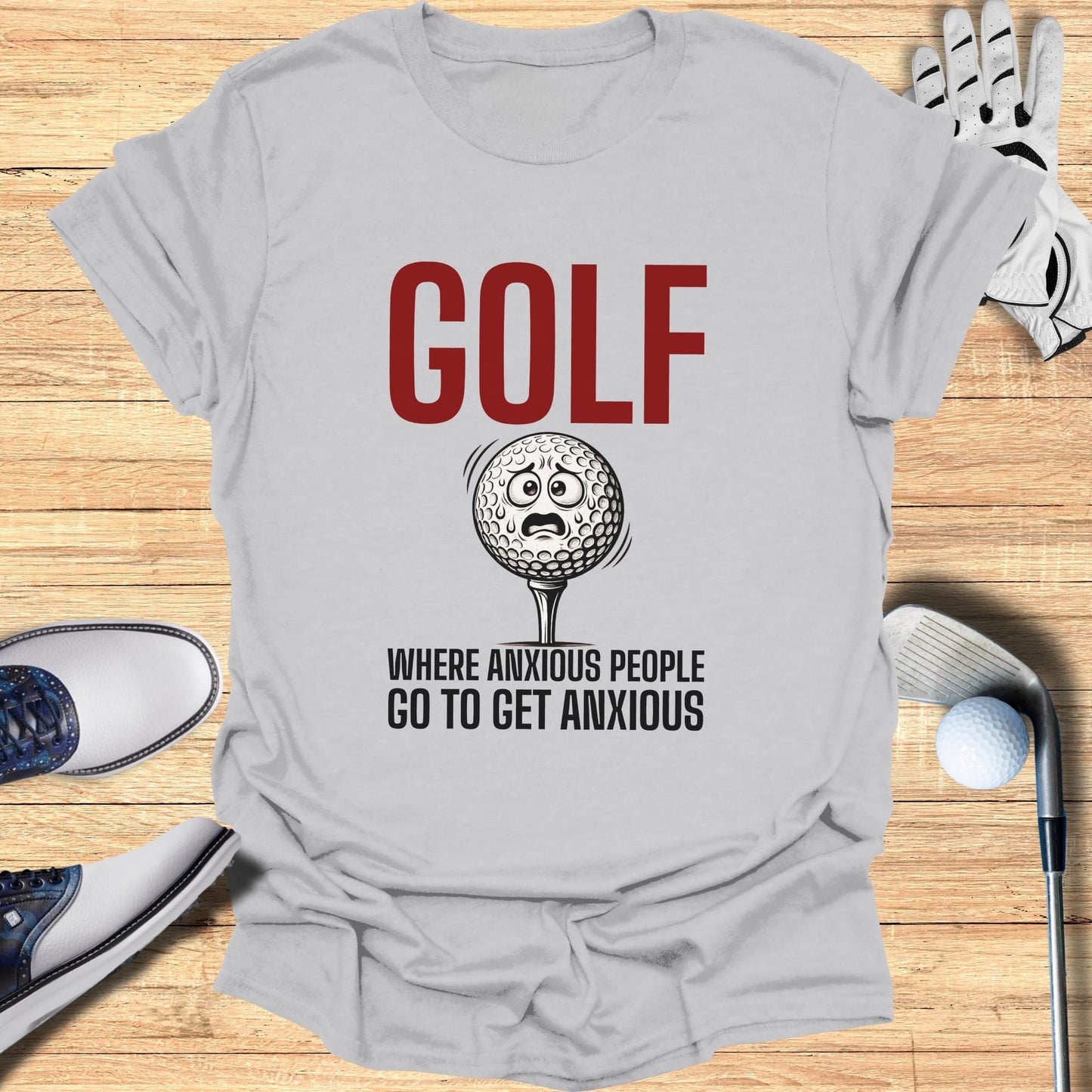 Gray t-shirt with "GOLF WHERE ANXIOUS PEOPLE GO TO GET ANXIOUS" and a nervous golf ball.