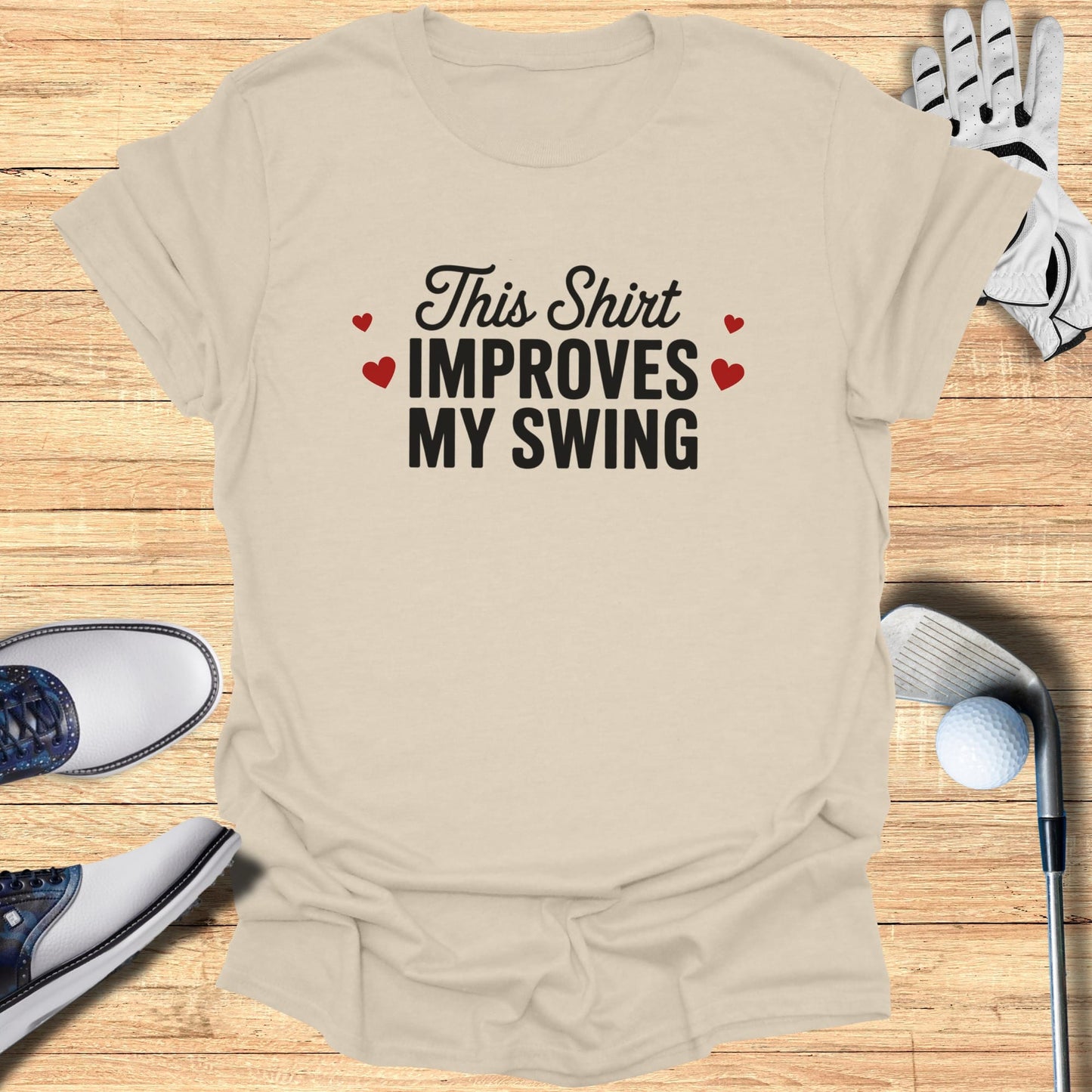 Tan t-shirt with "This Shirt Improves MY SWING" text and golf accessories.