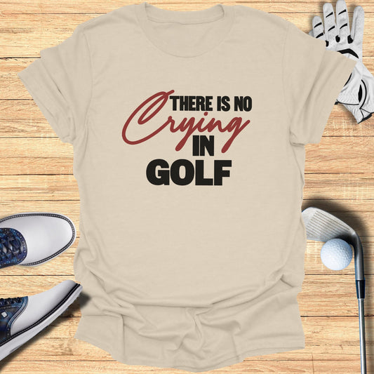 Cream t-shirt with "There is no crying in golf" graphic, golf shoes, glove, and club.