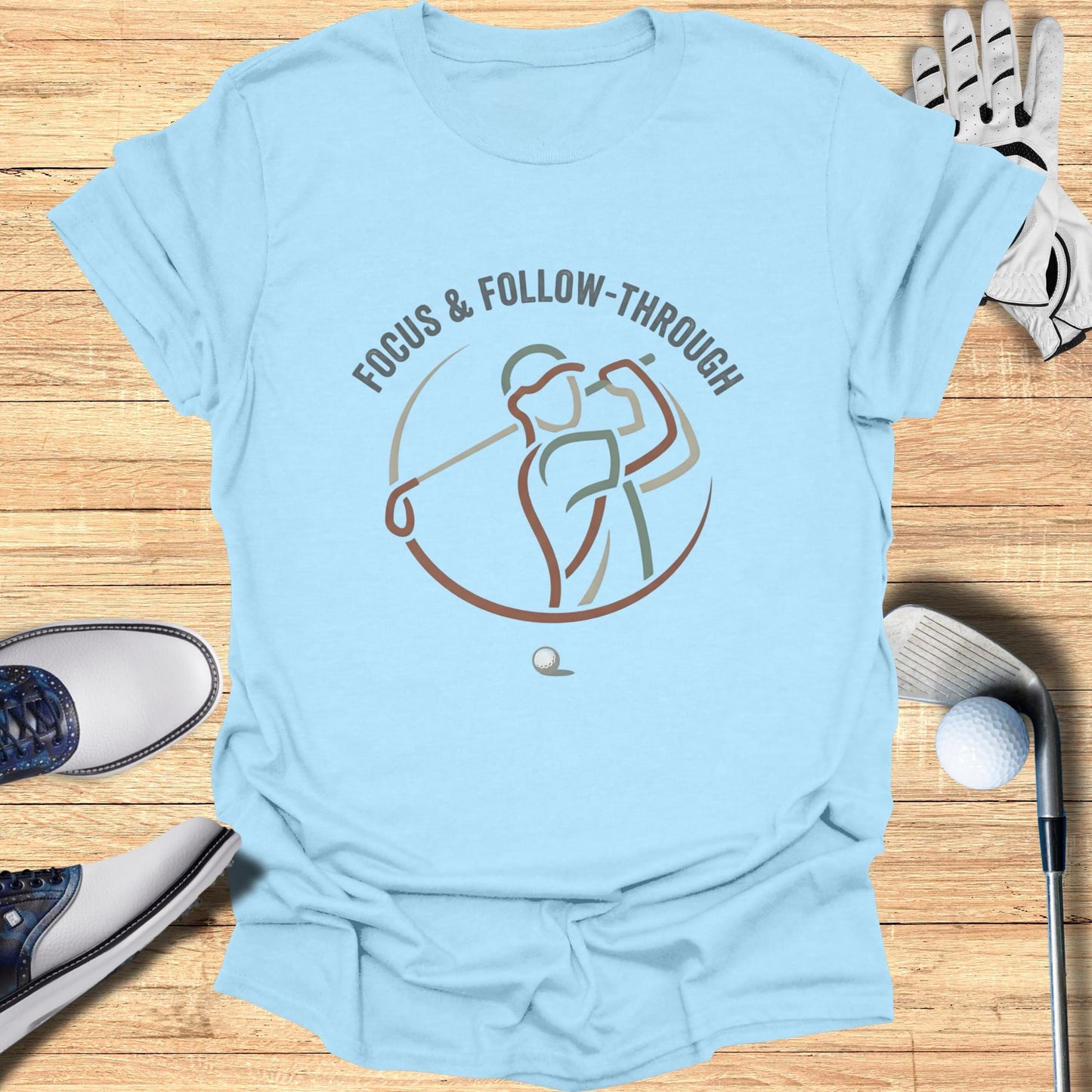 Light blue t-shirt with a graphic of a golfer and the text "FOCUS & FOLLOW-THROUGH".