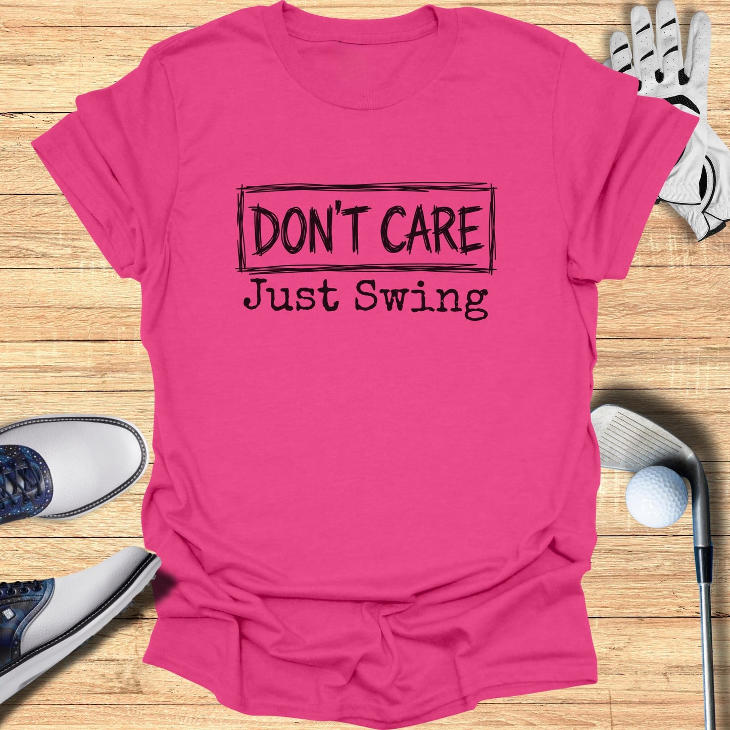 Pink t-shirt with "DON'T CARE Just Swing" text and golf accessories.