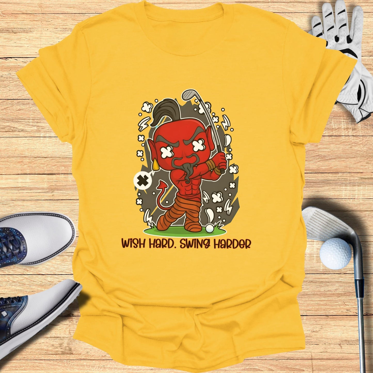 Yellow t-shirt with cartoon devil playing golf, "Wish Hard. Swing Harder."