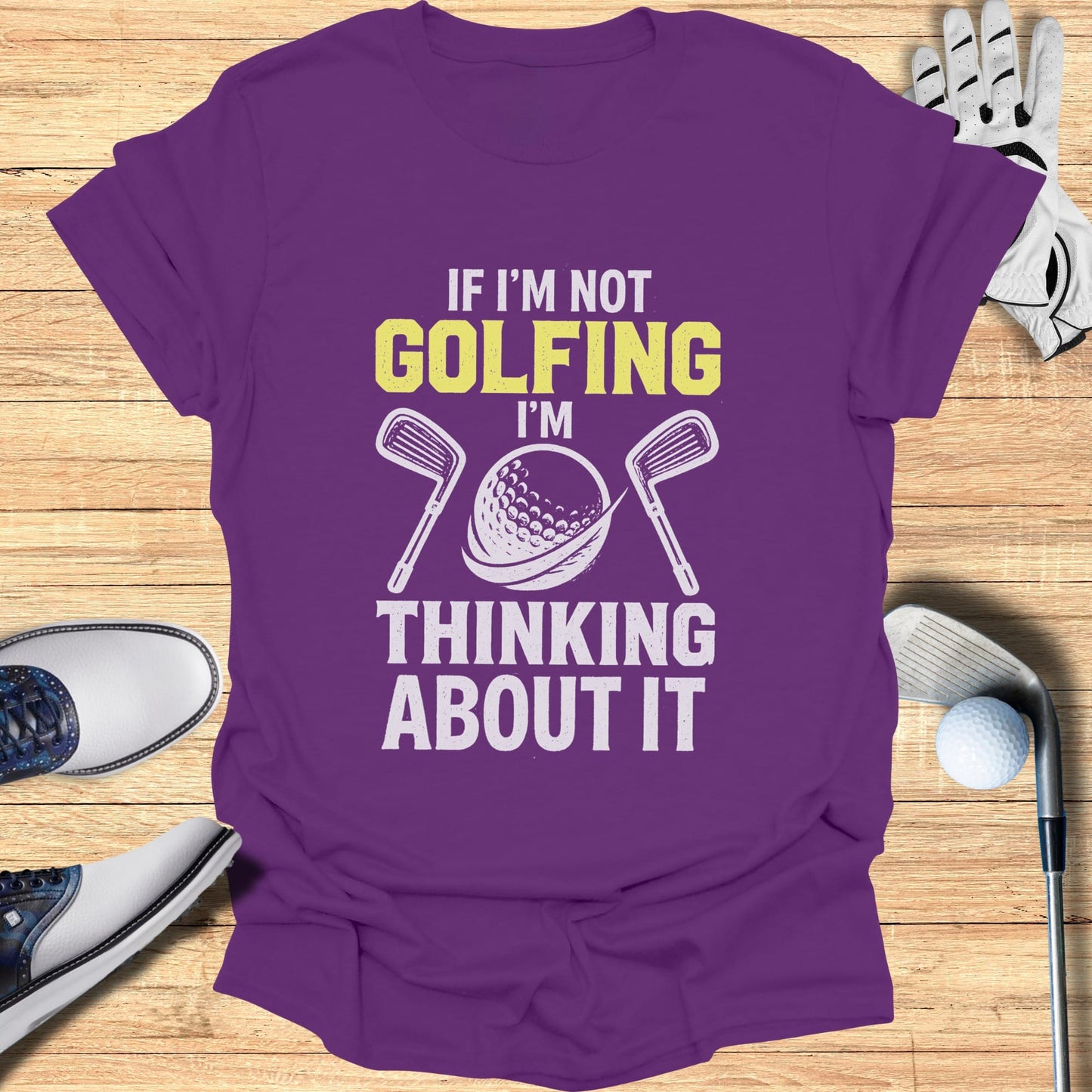 Purple t-shirt with "If I'm Not Golfing I'm Thinking About It" text and golf ball.