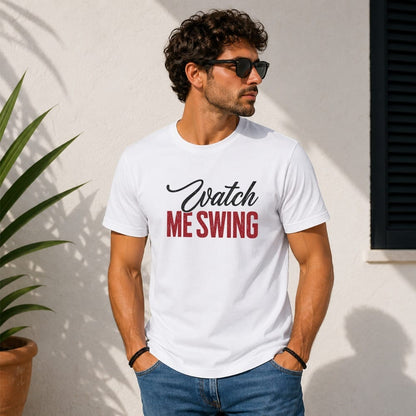 Man in white t-shirt with "Watch Me Swing" text, standing outside.