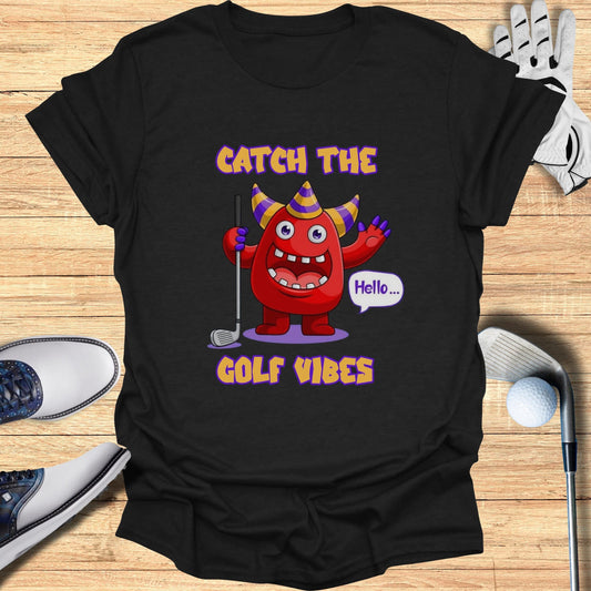 Red cartoon monster in party hat saying "Hello..." on a black t-shirt with "GOLF VIBES".