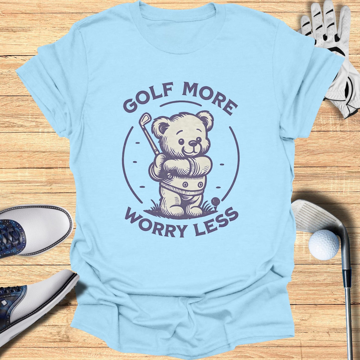 Light blue t-shirt with a cartoon teddy bear holding a golf club.