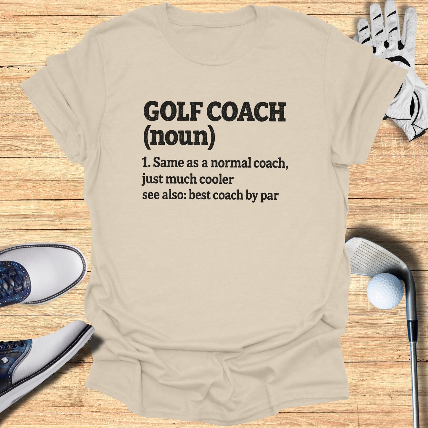 Beige t-shirt with "Golf Coach (noun)" definition printed in black.