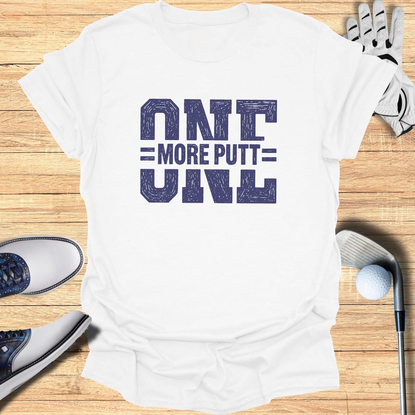 White t-shirt with bold blue text "ONE MORE PUTT".