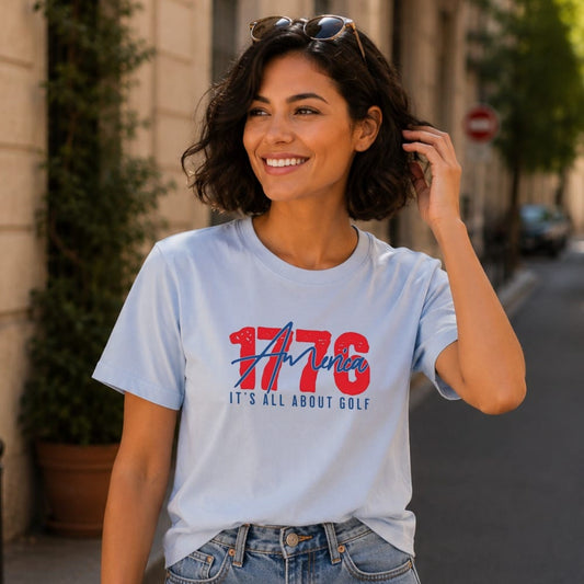 Light blue t-shirt with "1776 IT'S ALL ABOUT GOLF" graphic on chest.