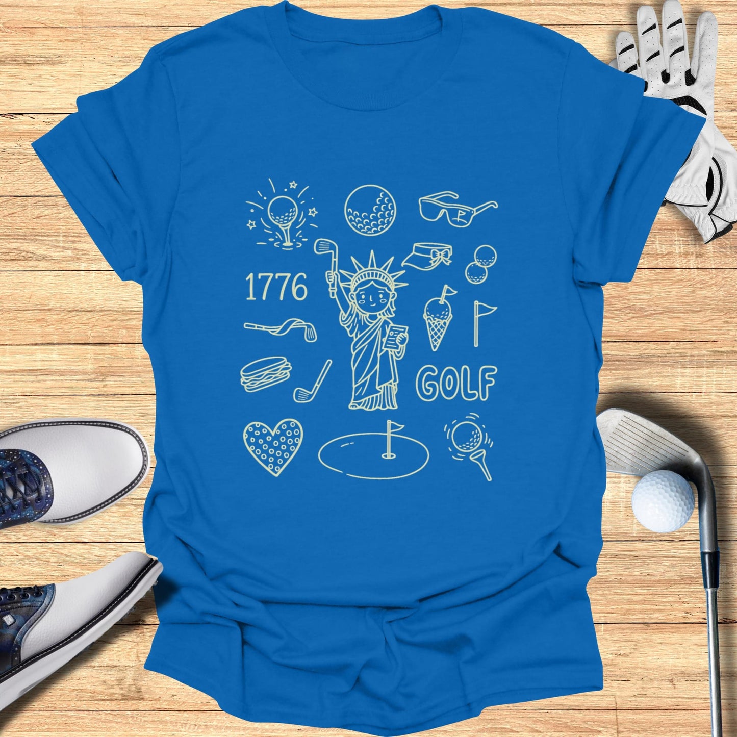 Blue t-shirt with line drawings of golf and patriotic items, including the Statue of Liberty.