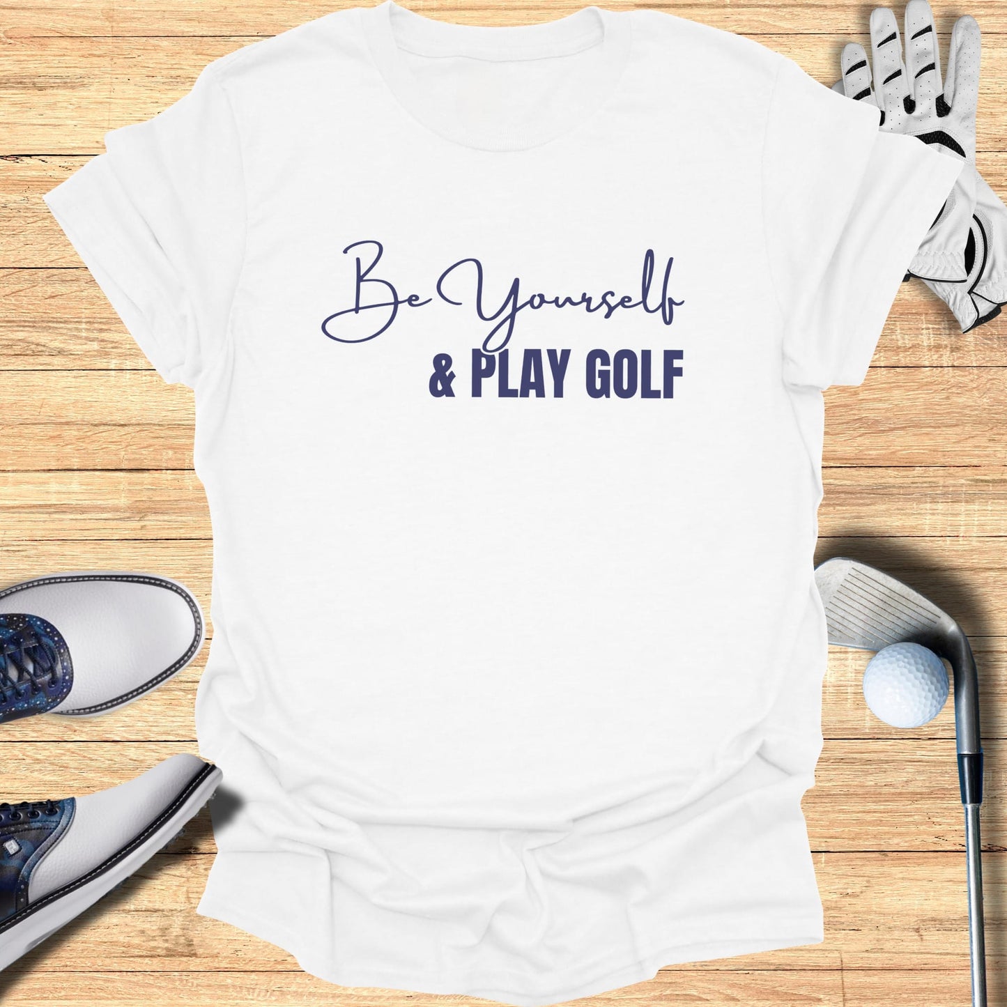 White t-shirt with "Be Yourself & Play Golf" text, golf shoes, and club.