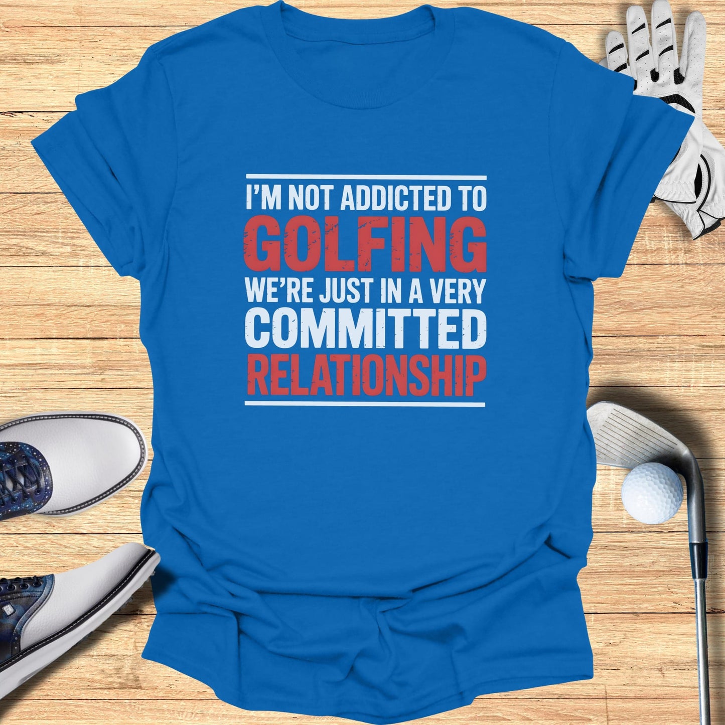Blue t-shirt with red and white text "I'm Not Addicted to Golfing We're Just in a Very Committed Relationship".
