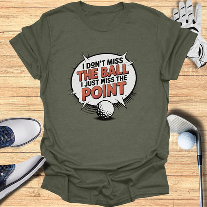 T-shirt with "I don't miss the ball I just miss the point" graphic and golf accessories.