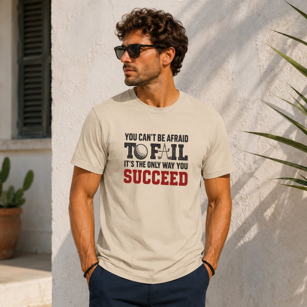 Man wearing beige t-shirt with "You Can't Be Afraid To Fail" text.