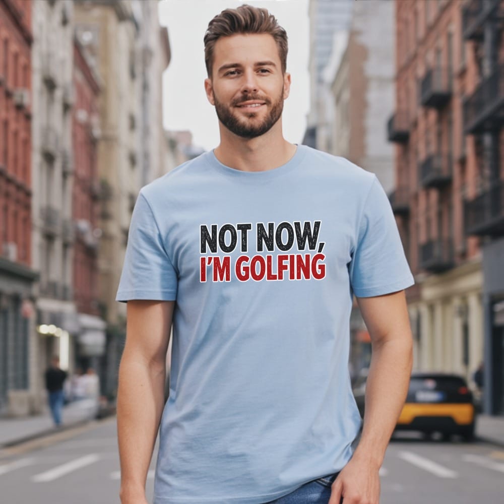 Man wearing a light blue t-shirt with "NOT NOW, I'M GOLFING" text.