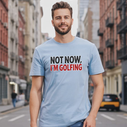 Man wearing a light blue t-shirt with "NOT NOW, I'M GOLFING" text.