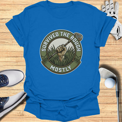 Blue t-shirt with circular graphic of a golf club in grass, text "SURVIVED THE ROUGH MOSTLY".