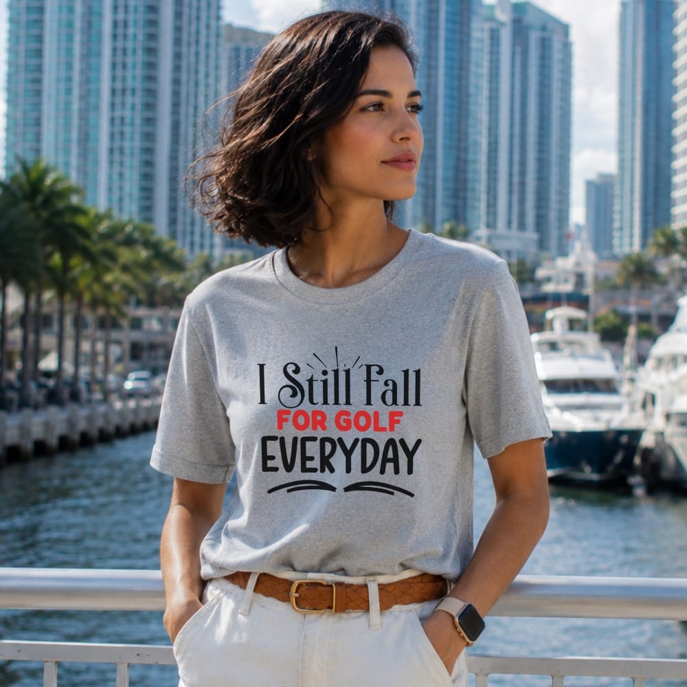Grey t-shirt with "I Still Fall For Golf Everyday" text, worn by a woman.