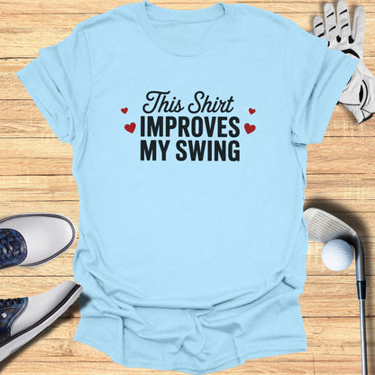 Light blue t-shirt with "This Shirt Improves My Swing" text and golf accessories.