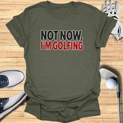 Olive green t-shirt with "NOT NOW, I'M GOLFING" in red and black lettering.