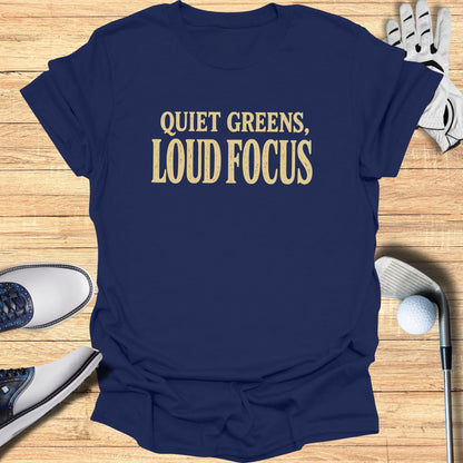 Navy t-shirt with "QUIET GREENS, LOUD FOCUS" in gold text.
