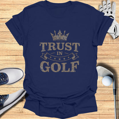 Navy t-shirt with "Trust in Golf" text and crown graphic.