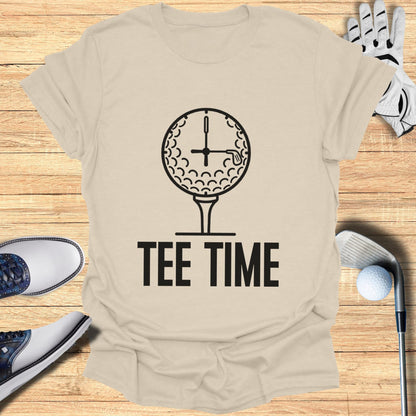 Tee Time text with a golf ball clock on a beige t-shirt.